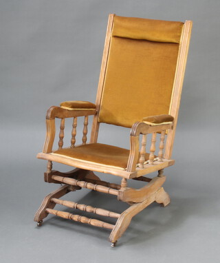 An American bleached mahogany rocking chair with bobbin turned decoration, upholstered in light brown material 102cm h x 54cm w x 51cm d (seat 30cm x 32cm) 