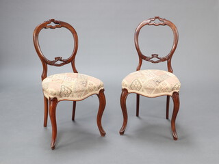 A pair of Victorian carved walnut balloon back dining chairs with pierced mid rails and overstuffed seats of serpentine outline, raised on French cabriole supports 90cm h x 47cm w x 41cm d (seat 34cm x 30cm) 