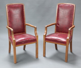 A set of 12 1930's oak framed open arm conference chairs, the seats and backs upholstered in red rexine 116cm h x 55cm w  51cm d (seats 34cm x 34cm) (2 shown in photo)