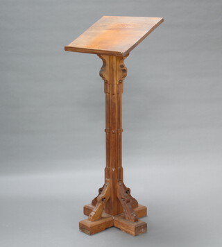 A Victorian ecclesiastical pitch pine lectern raised on a reeded support with triform base 142cm h x 56cm w x 42cm d, there is pitting and scratching in places  