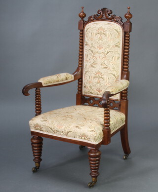 A Victorian walnut open armchair with bobbin turned columns to the side, upholstered seat and back, raised on turned supports 102cm h x 59cm w x 49cm d (seat 34cm x 33cm) 