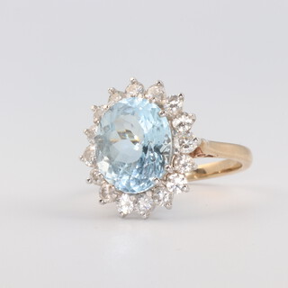 A 9ct yellow gold oval topaz and diamond cluster ring, the topaz 12mm x 10mm, the 16 brilliant cut diamonds each approx. 0.05ct, 5.6 grams, size L 1/2