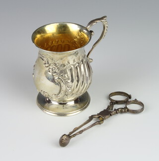 An Edwardian repousse silver baluster mug with S scroll handle and vacant cartouche Birmingham 1908 together with a pair of Georgian silver scissors nips 110 grams 