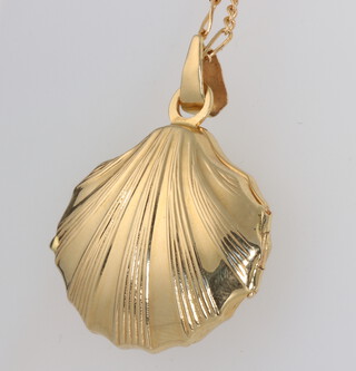 A yellow metal stamped 750 shell shaped locket on an 18ct chain, the chain 4.6 grams 49cm, the locket is gross 9.9 grams  