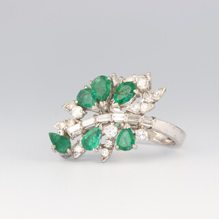 A white metal stamped 18k emerald and diamond cocktail ring, the 6 pear cut emeralds approx. 1.5ct together with brilliant and baguette cut diamonds approx. 1.5ct, stamped Kevin, 10.2 grams, size N 