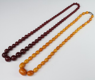 An orange amberoid bead necklace 74cm, a red ditto 74cm 