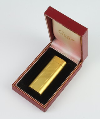 A Cartier gilt cased engine turned cigarette lighter, boxed 
