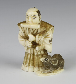 A Meiji Period Japanese ivory netsuke in the form of a standing Samurai with a rat beside him, signed, 6cm 