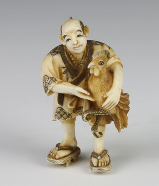 A Meiji Period Japanese carved ivory netsuke in the form of a man holding a cockerel, signed, 6cm  