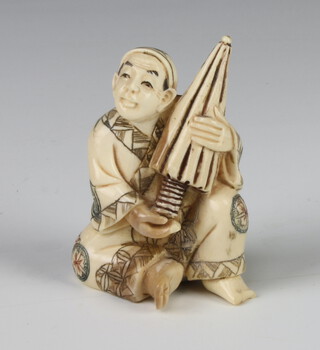 A Meiji Period Japanese ivory netsuke in the form of a seated man holding a large parasol with painted detail, signed, 5cm (chipped foot and toe) 