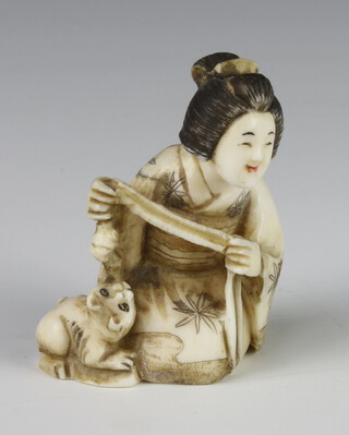 A Meiji Period Japanese carved ivory netsuke in the form of a seated lady with a cat beside her, signed, 5cm