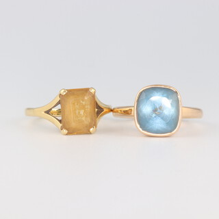 An 18ct yellow gold citrine ring size M 1/2, a yellow metal topaz ring size M 1/2, gross weight 9 grams 