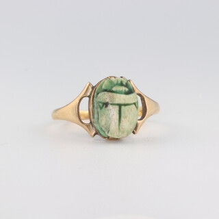 A yellow metal stamped 18ct scarab ring, size S 1/2, 3.6 grams 