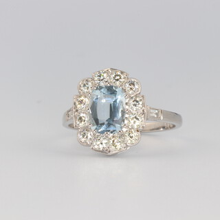 A white metal stamped plat oval aquamarine and diamond ring, the centre stone 1.1ct surrounded by brilliant cut diamonds 0.75ct, size O 1/2, 4.6 grams 