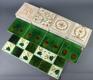 Four Art Nouveau tiles decorated with stylised flowers (1 chipped) and 3 similar (all chipped), 11 Mintons ditto with floral scrolls and ribbons (minor chips to the edges) and 10 Edwardian tiles decorated with flowers (chips to edges) 
