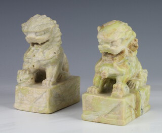 A pair of carved soapstone figures of Shi Shi raised on rectangular bases 12cm 
