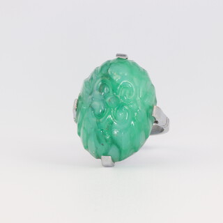 An Art Deco white metal carved hardstone oval green stone cocktail ring 7.8 grams, size N 