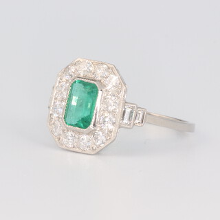 A white metal stamped plat emerald and diamond Art Deco style ring, the emerald 0.7ct, the brilliant cut diamonds 0.9ct, 3.3 grams, size N 1/2