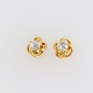 A pair of yellow metal twist mount earrings, each set with a brilliant cut diamond approx. 0.5ct, SI2 colour G/H, 5.1 grams 