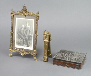A gilt metal easel photograph frame 24cm h x 13cm (hinge f), a pair of brass nutcrackers in the form of a longcase clock and a Japanese metal box the lid decorated elephants walking over a bridge 3cm x 12cm x 9cm  
