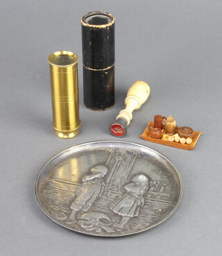 A circular embossed metal tray decorated standing boy and girl by a pump with broken pitcher 12cm, a brass 3 draw pocket telescope, a seal in the form of a gentleman's head with turned bone terminal 7cm, a miniature wooden tray 5cm x 2.5cm, a miniature wooden side handled coffee pot, 2 jar and covers, 5 turned miniature cups 