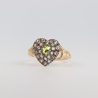 A yellow metal ring set with a pear cut peridot surrounded in a diamond set heart shaped mount, 2.9 grams, size O