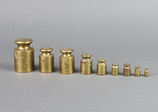 Nine cylindrical brass weights 500g, 200g (x2), 100g, 50g, 20g (x2), 10g and 5g 