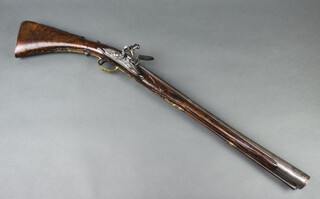 An 18th Century Italian flintlock blunderbuss with walnut folding stock, the 55cm steel barrel with maker/armourers seal mark surrounded by 9 fleur de lis, the steel lock marked G Myri, the walnut folding stock with gilt furniture, the trigger guard with portrait bust, complete with wooden ramrod 88cm overall 