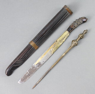 An Eastern eating set comprising a knife with 12cm blade, bodkin and skewer contained in a carved hardwood sheath 36cm overall 