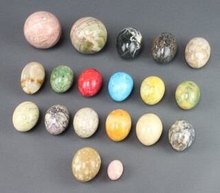 Two circular carved hardstone balls 6cm together with a collection of 16 turned marble eggs 