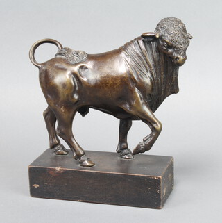 A bronze figure of a walking bull, raised on a wooden base 25cm h x 17cm w x 8cm d 