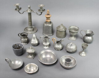 A pewter twin light candelabrum, a pewter table bell with wooden finial 22cm x 9cm (base misshapen), a cylindrical ginger jar and cover 12cm h, circular pewter lid, 3 pewter jugs and other minor pewter items 