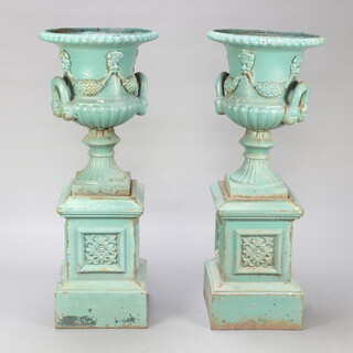 A pair of Victorian cast iron garden urns of campanula form with lobed bodies, raised on square bases, raised on further square bases 111cm h x 44cm diam. 