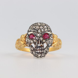 A yellow metal diamond and ruby ring in the form of a skull 2.5 grams, size P 1/2