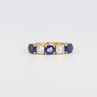An 18ct yellow gold sapphire and diamond ring the 2 brilliant cut diamonds 0.4ct, the 3 sapphires 1.2ct, size N 1/2, 3 grams