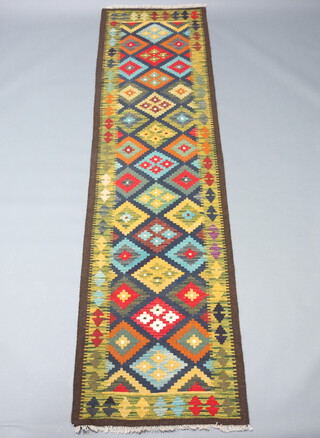 A black, blue and brown ground Maimana Kilim runner with overall diamond design 302cm x 82cm 