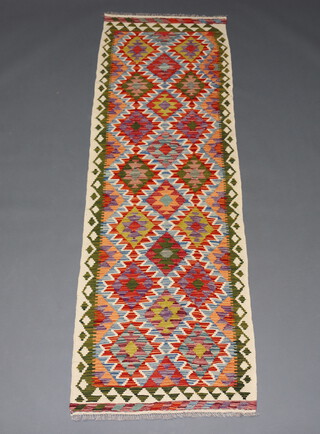 A white, purple, turquoise and green ground Chobi Kilim runner with all over geometric design 248cm x 79cm 
