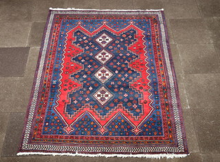 A blue and red ground North West Persian rug with 4 diamonds to the centre within a multi row border 226cm x 175cm 