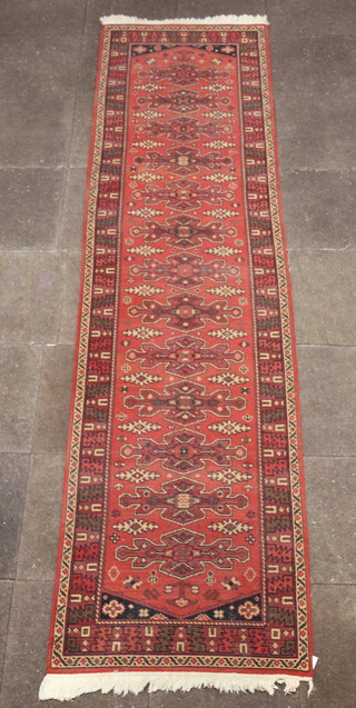 A tan ground machine made Afghan style runner with 13 stylised medallions to the centre, 346cm x 91cm 