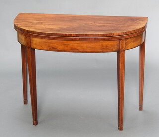 An inlaid Georgian mahogany demi-lune card table raised on square tapered supports ending in spade feet 71cm h x 92cm w x 44cm 