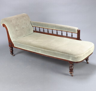 A late Victorian mahogany show frame chaise longue upholstered in green buttoned material with bobbin turned decoration to the back, raised on turned supports 71cm h x 14qcm l x 64cm d (seat 120cm x 28cm) 