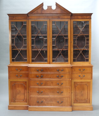 A Georgian style mahogany breakfront library bookcase with shaped cornice, fitted cupboards enclosed by astragal glazed panelled doors, the base with well fitted secretaire drawer above 3 long drawers flanked by 4 short drawers above a cupboard raised on a platform base 230cm h x 181cm w x 49cm d 