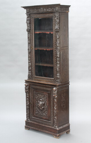 A Victorian carved oak bookcase on cabinet with moulded cornice, fitted shelves enclosed by a glazed panelled door, the base enclosed by a panelled door (this cabinet is in one section and does not split) 202cm h x 69cm w x 31cm d  