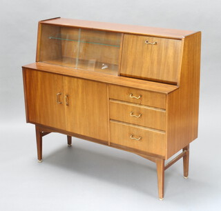 Mid-Century, a Nathan teak sideboard, the raised back fitted a cupboard enclosed by glazed sliding panelled doors with cocktail unit to the side above 3 drawers and cupboard enclosed by panelled doors, raised on turned supports 107cm h x 122cm w x 44cm d 