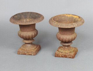 A pair of Victorian style circular cast iron urns with egg and dart borders, lobed bodies, raised on square bases 23cm h x 23cm diam. 
