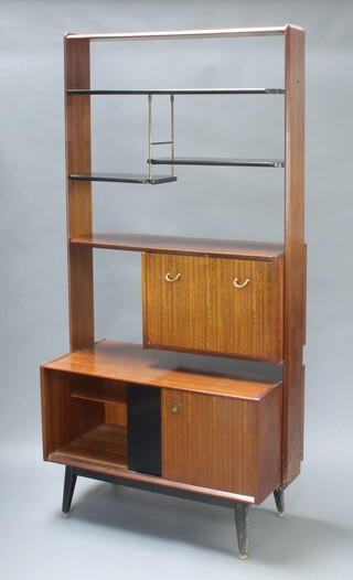 A 1950's G-Plan E Gomme Librenza teak and ebonised room divider/wall unit, the upper section fitted adjustable shelves, the fall front revealing a fitted interior, the base enclosed by sliding panelled doors, raised on turned supports 191cm h x 91cm w x 47cm d (some contact marks in places) 