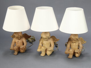 Three carved wooden table lamps in the form of kneeling cherubs 24cm x 18cm x 19cm 