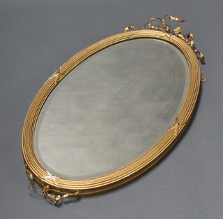 A 19th Century style oval bevelled plate wall mirror contained in a decorative gilt reeded frame with swag decoration 72cm x 42cm (some plaster loss to the swags) 
