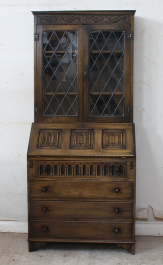 A carved oak bureau bookcase, the upper section fitted shelves enclosed by lead glazed panelled doors, the fall front revealing a fitted interior above 4 long drawers 176cm h x 76cm w x 44cm d 
