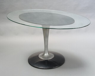 A contemporary oval laminated and chrome pedestal dining table with black smoked glass top, raised on a circular spreading foot 70cm h x 135cm l x 86cm d  